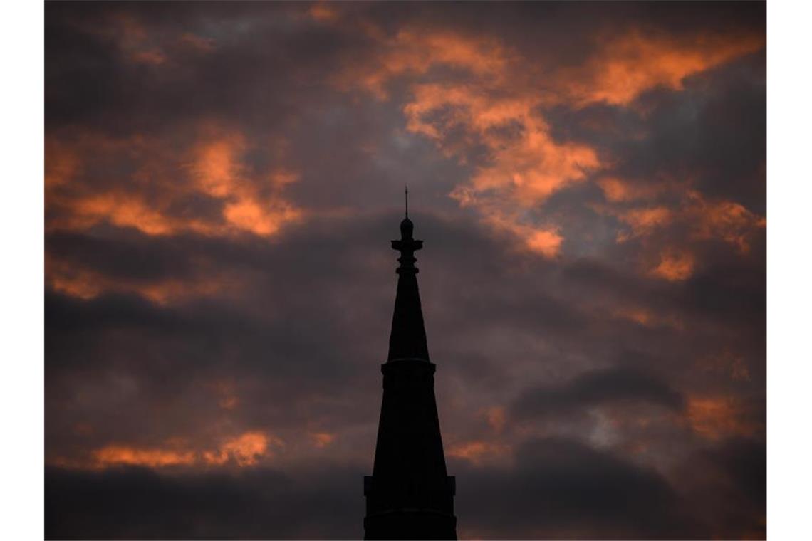 Nasses Wochenende im Südwesten Die Sonne strahlt am Morgen die Wolken hinter der Matthäuskirche in Stuttgart an. Foto: Sebastian Gollnow/dpa/Archivbild