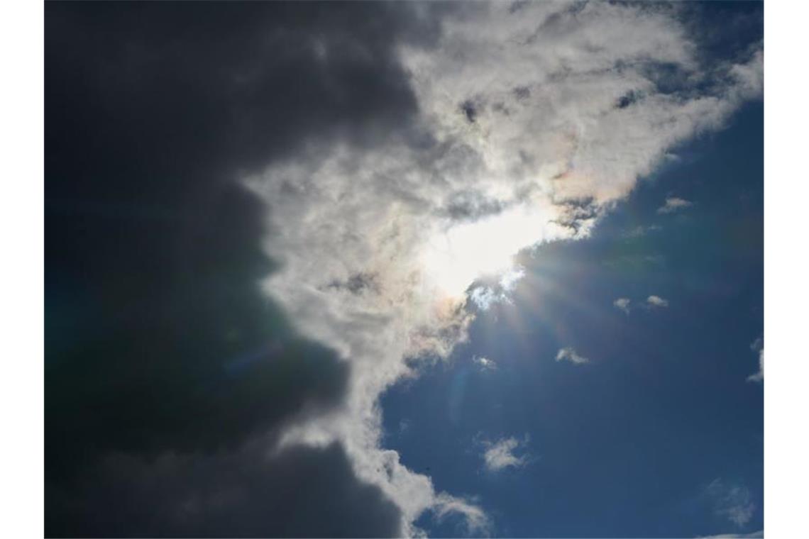 Die Sonne wird von Regenwolken verdeckt. Foto: Annette Riedl/dpa/Archivbild