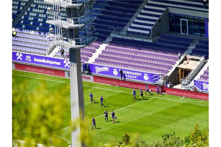 Die Spieler des FC Erzgebirge Aue laufen vor leeren Zuschauerrängen in das Erzgebirgsstadion ein. Foto: Hendrik Schmidt/dpa-Zentralbild/ZB