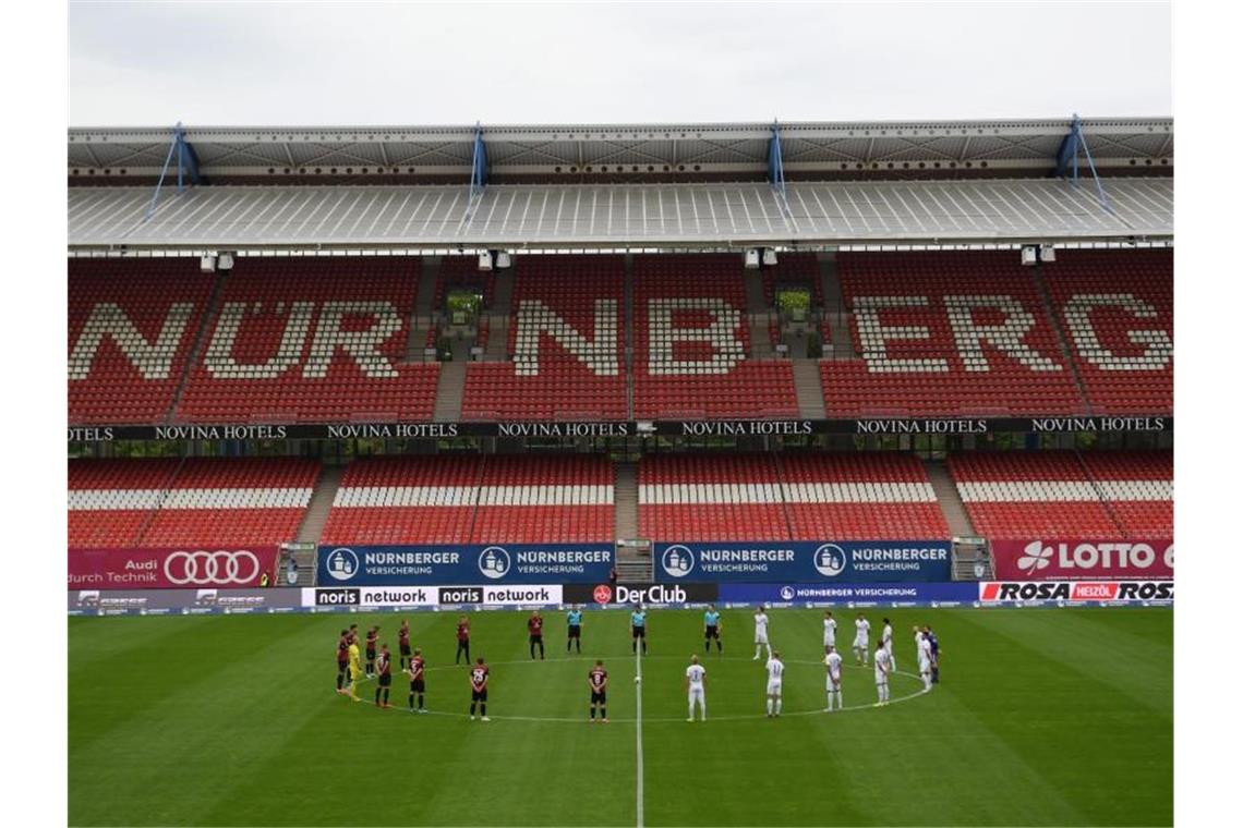 Zweitliga-Spieltag startet mit Schweigeminute Die Spieler halten eine Schweigeminute zum Gedenken an die Opfer der Coronavirus-Pandemie. Foto: Matthias Hangst/Getty Images Europe/Pool/dpa