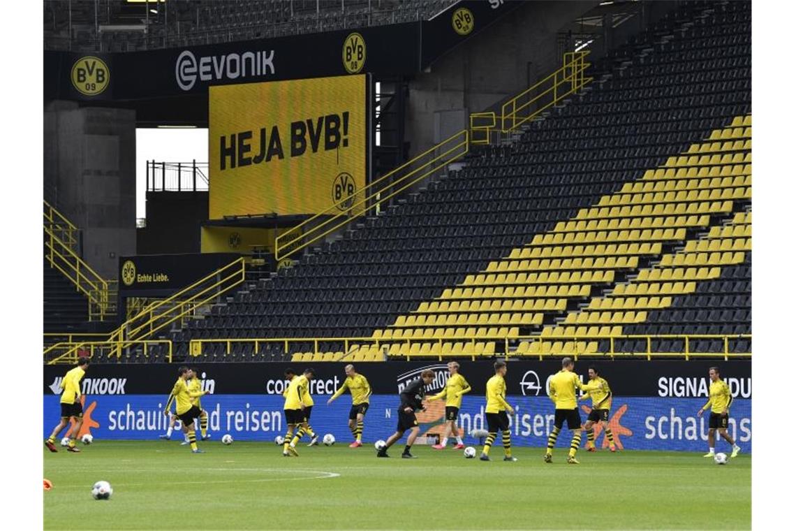 Corona-Pause vorbei: Bundesliga spielt wieder Die Spieler von Borussia Dortmund wärmen sich vor dem Revierderby gegen Schalke im Signal-Iduna-Park Spiel auf. Foto: Martin Meissner/AP-Pool/dpa