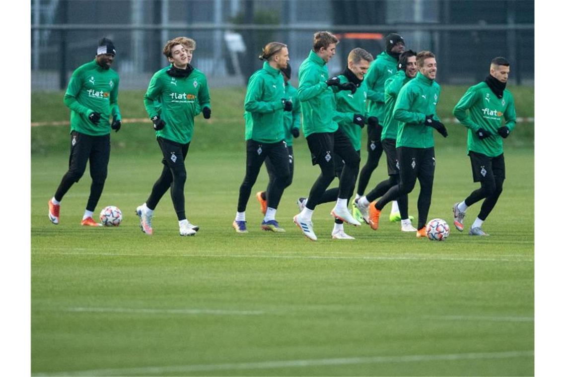 Gladbach ist heiß aufs Champions-League-Achtelfinale Die Spieler von Borussia Mönchengladbach laufen sich für das Training warm. Foto: Marius Becker/dpa