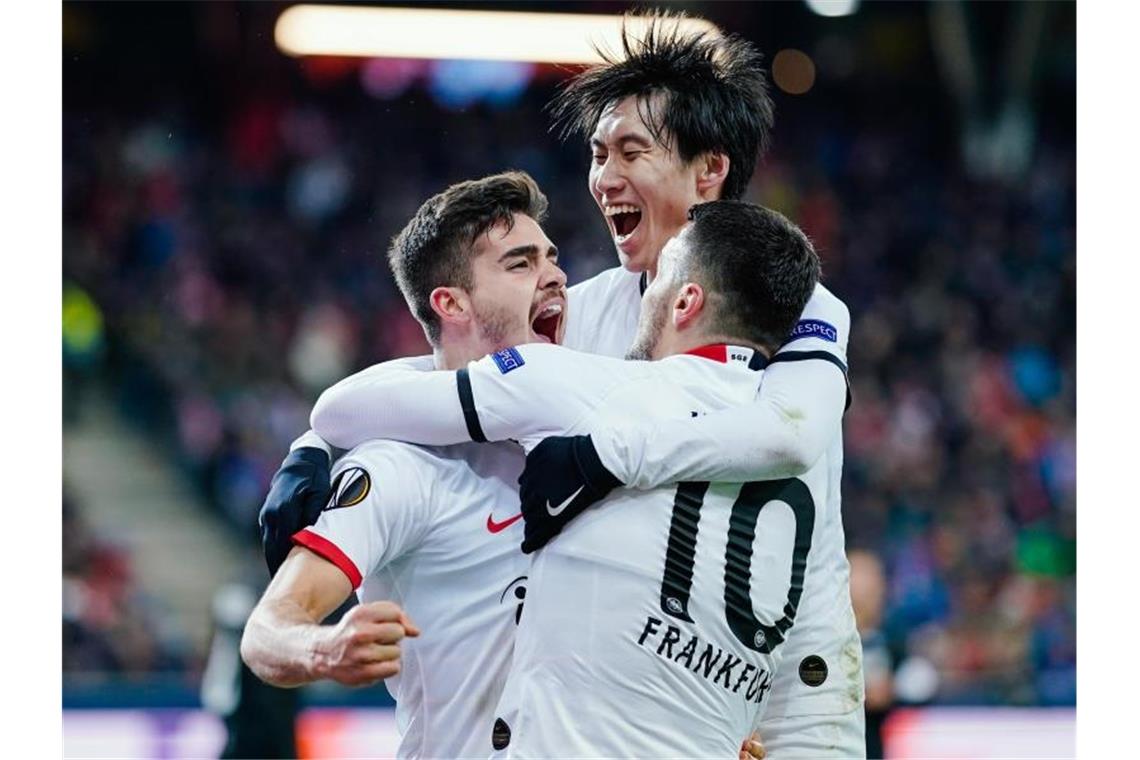 Die Spieler von Eintracht Frankfurt feiern den Treffer zum Ausgleich bei Red Bull Salzburg. Foto: Uwe Anspach/dpa