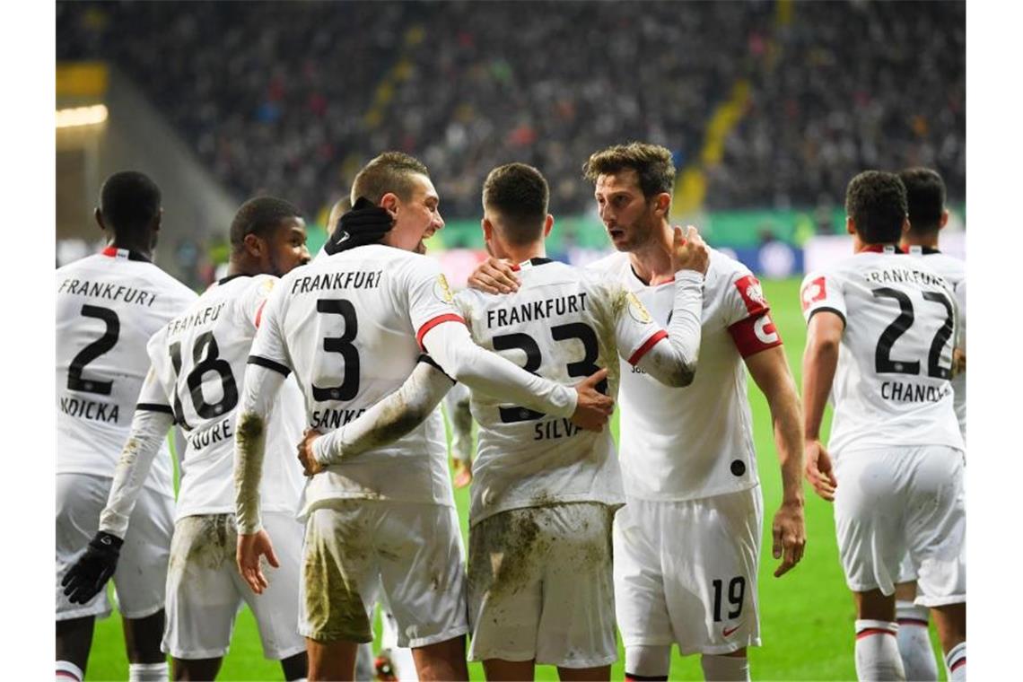 Frankfurt im Halbfinale - Werder über Elfer verärgert Die Spieler von Eintracht Frankfurt feiern die Führung im Spiel gegen Werder Bremen. Foto: Arne Dedert/dpa