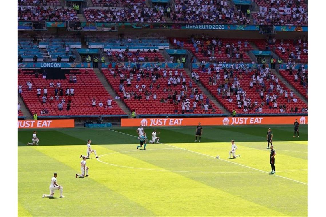 Die Spieler von England knien vor Spielbeginn auf dem Rasen. Foto: Martin Rickett/PA Wire/dpa