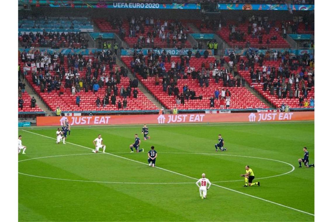 Kniefall und Regenbogenbinde: Symbolische Gesten oder mehr? Die Spieler von England und Schottland knien vor der Partie im Wembley-Stadion. Foto: Mike Egerton/PA Wire/dpa