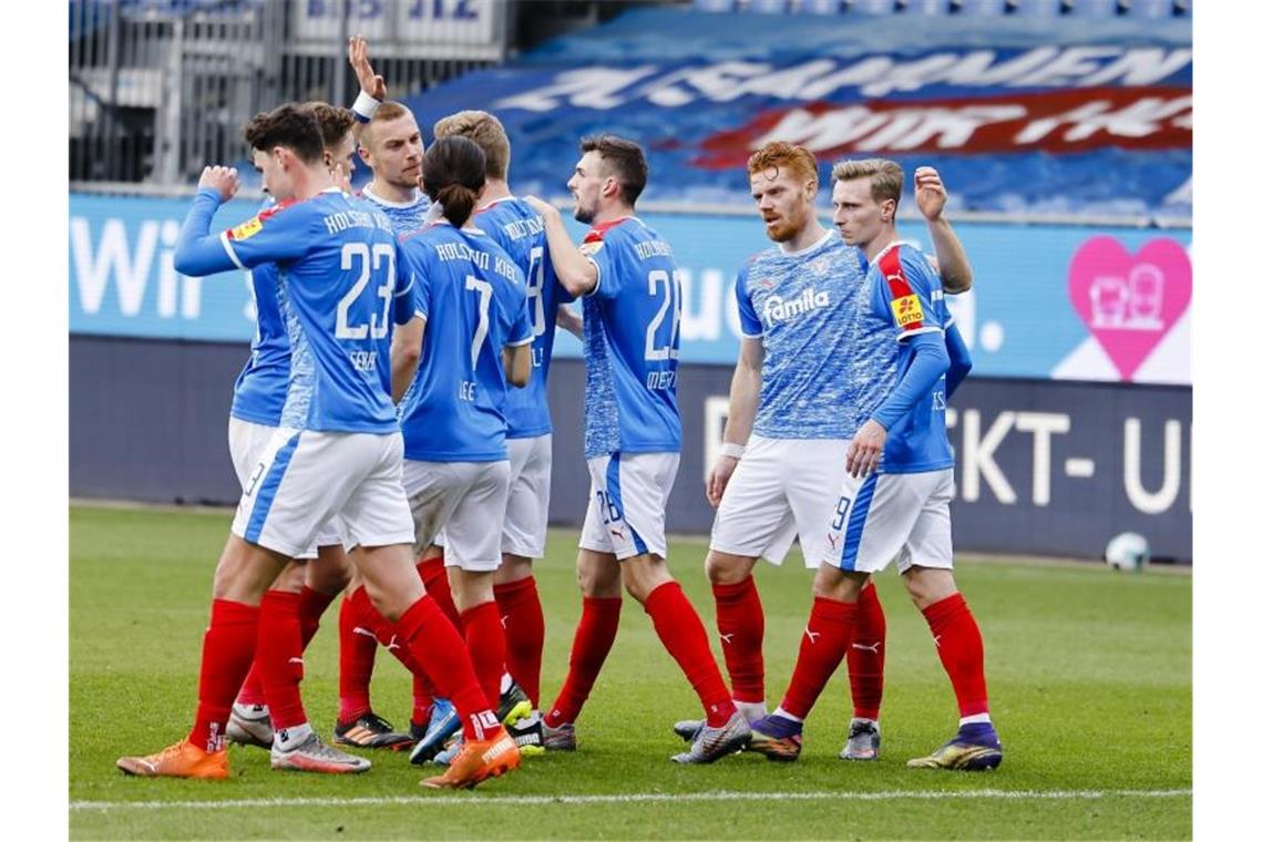 Die Spieler von Holstein Kiel feiern den Sieg gegen Erzgebirge Aue. Foto: Frank Molter/dpa