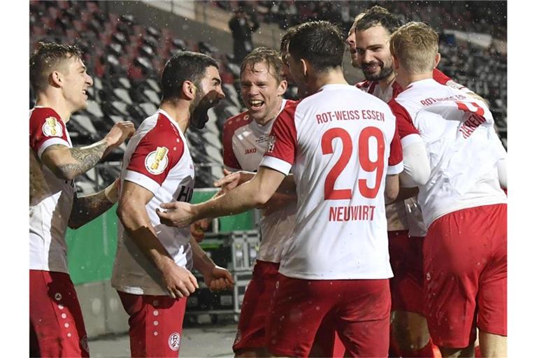 Die Spieler von Rot-Weiss Essen feiern Oguzhan Kefkir (2.v.l) nach seinem Tor gegen Leverkusen. Foto: Martin Meissner/AP POOL/dpa