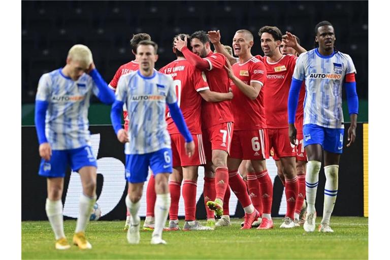 Die Spieler von Union Berlin (in rot) feiern das 2:0 gegen Hertha BSC. Foto: Sören Stache/dpa