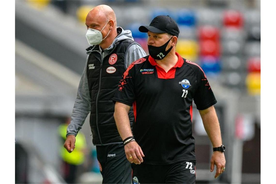 Die Teams von Düsseldorf-Coach Uwe Rösler (l) und Paderborns Trainer Steffen Baumgart trennten sich torlos. Foto: Sascha Schuermann/AFP-Pool/dpa