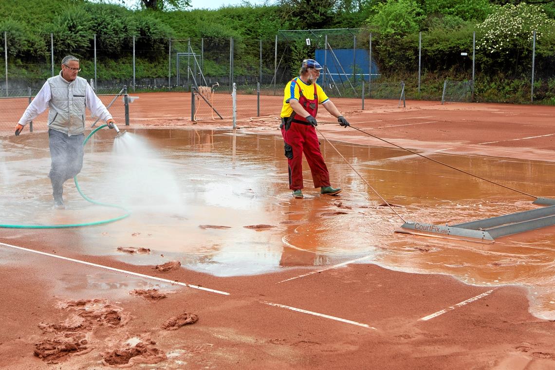 Die Tennisklubs in Baden-Württemberg bereiten sich darauf vor, dass es möglichst bald mit ihrem Sport wieder losgehen kann. Beim SV Unterweissach sorgen Mitglieder wie Uwe Hassler (links) und Manfred Kunkel mit viel Wasser und Handarbeit dafür, dass die Plätze in optimalem Zustand sind, wenn ihr Sport von der Politik möglichst in den nächsten Tagen die Freigabe erhält. Foto: A. Becher