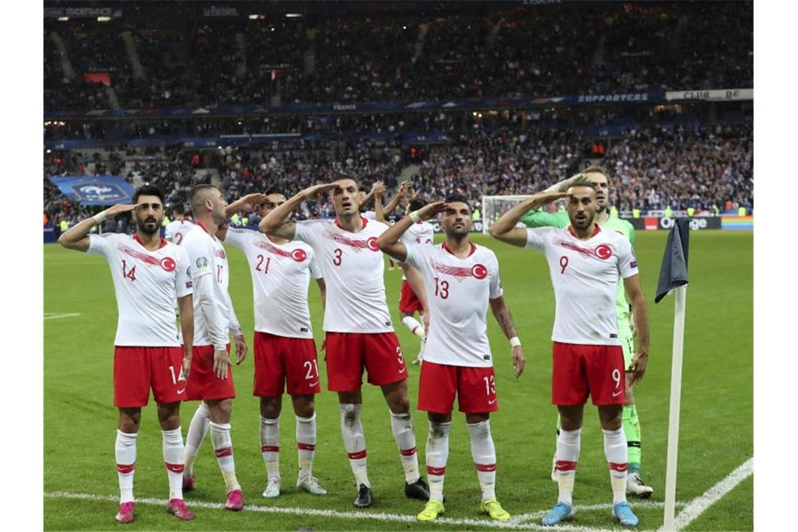 Die türkischen Spieler Mahmut Tekdemir (l-r), Burak Yilmaz, Irfan Kahveci, Merih Demiral, Umut Meras, Mert Günok und Cenk Tosun salutiern vor den Fans. Foto: Thibault Camus/AP/dpa