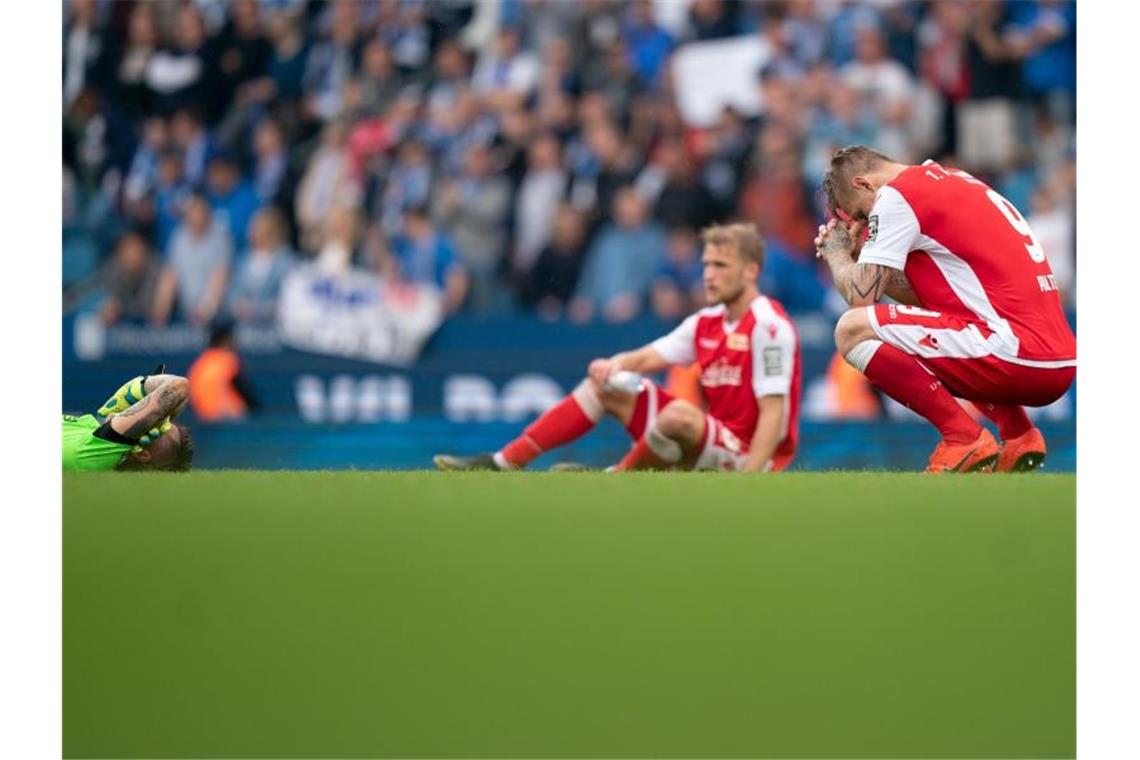 Die Union-Spieler sitzen nach dem Schlusspfiff enttäuscht auf dem Rasen. Foto: Bernd Thissen