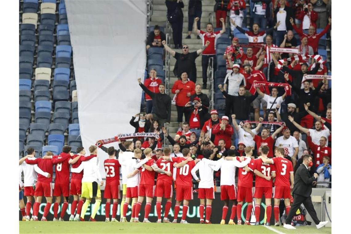 Die Unioner lassen sich von den mitgereisten Fans feiern. Foto: Ariel Schalit/AP/dpa