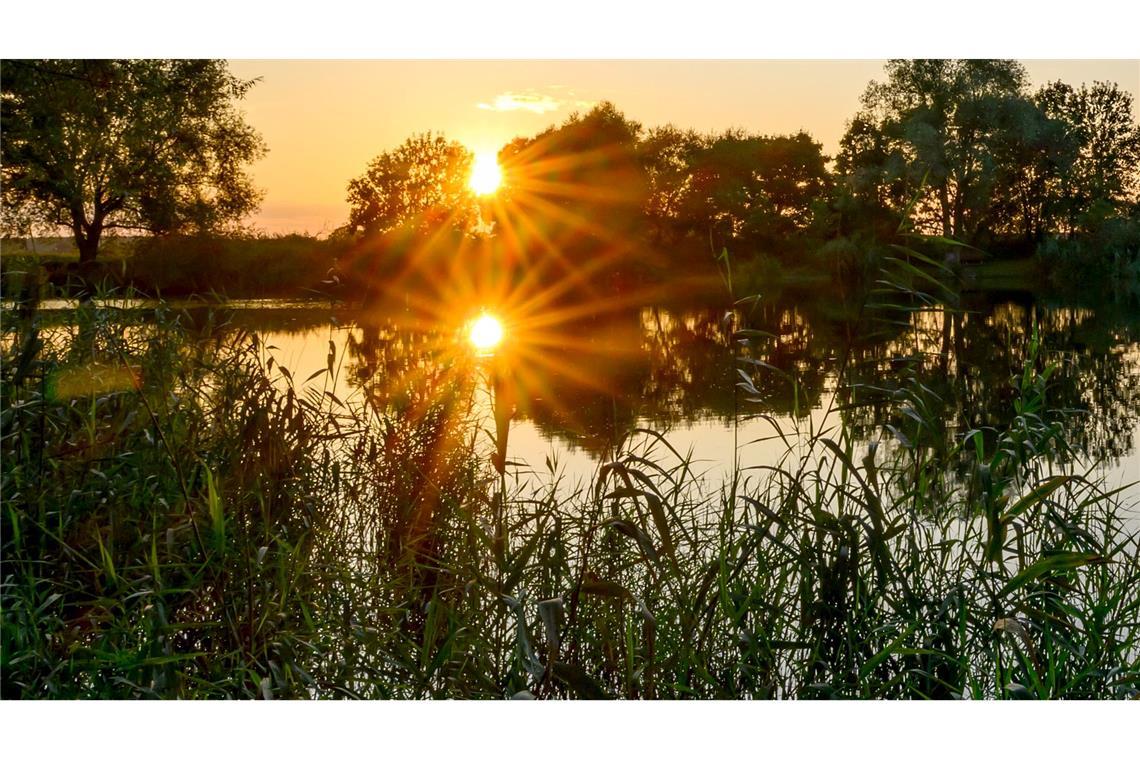 Bilder des Tages Die untergehende Sonne spiegelt sich in einem kleinen See im östlichen Brandenburg.