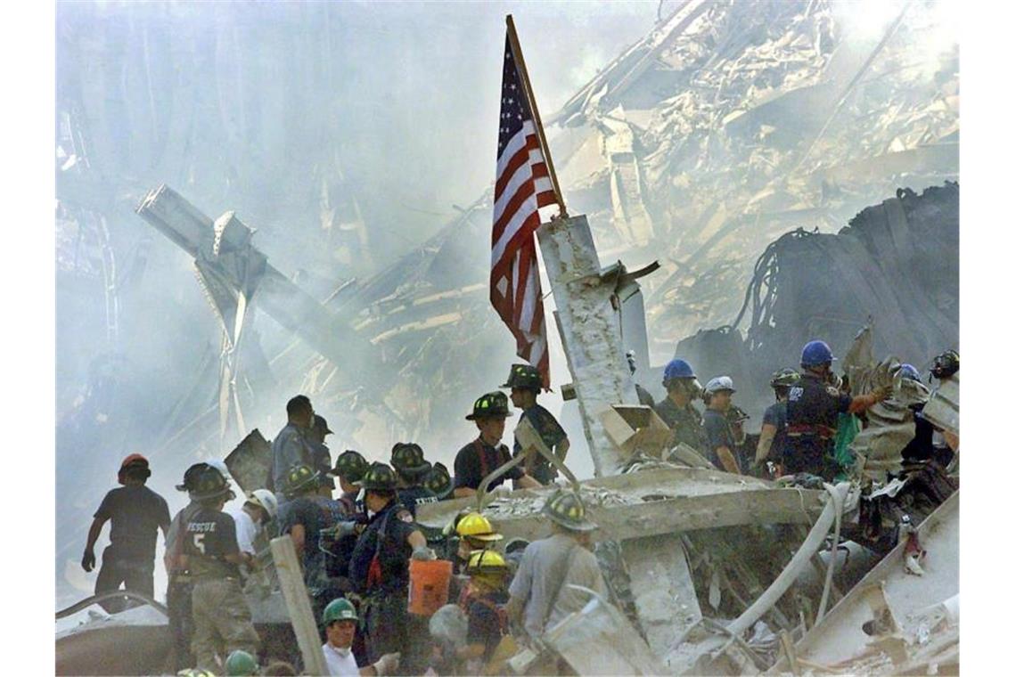 Die US-Flagge wird am Tag nach dem Anschlag auf den Trümmern der eingestürzten Twin Towers gehisst. Foto: Beth A. Keiser / Pool/AP POOL/EPA FILE/dpa