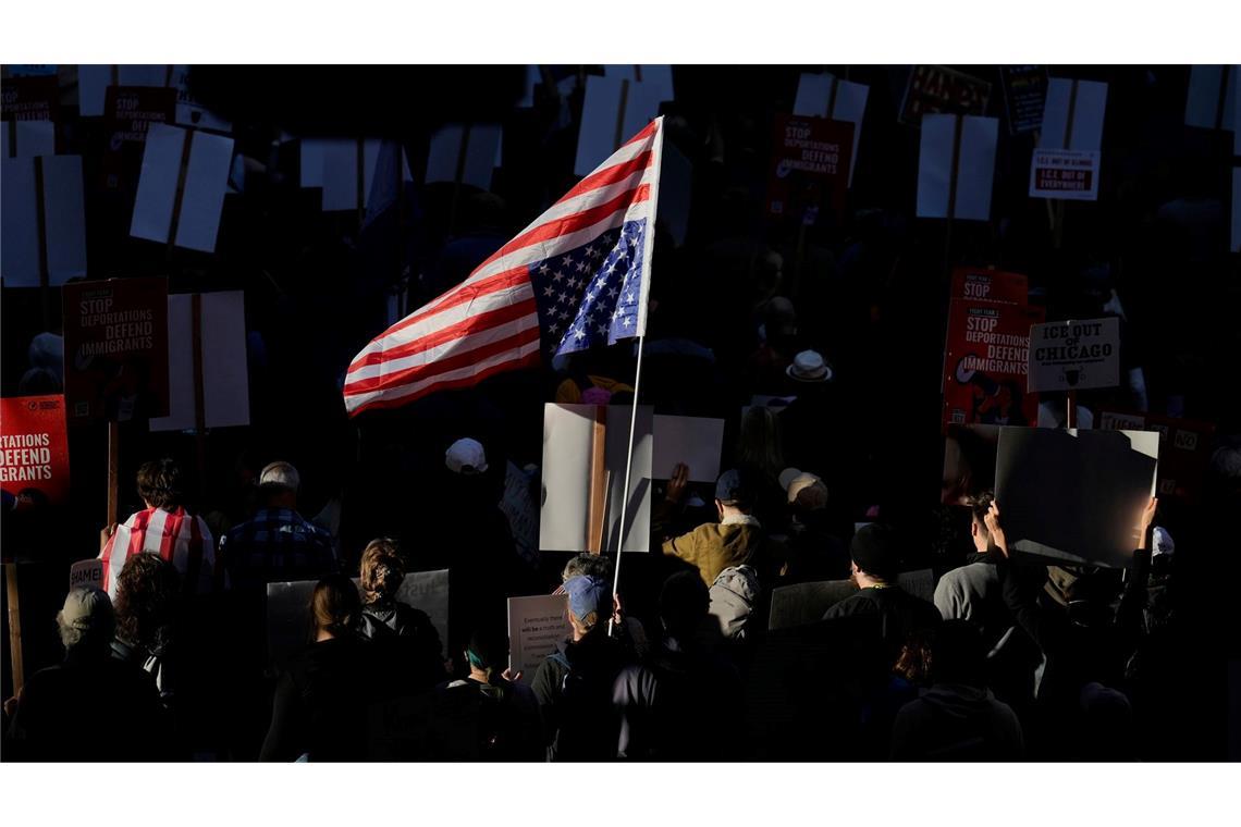 Die US-Flagge wird bei einem Demonstrationszug durch Chicago von der Sonne angestrahlt.