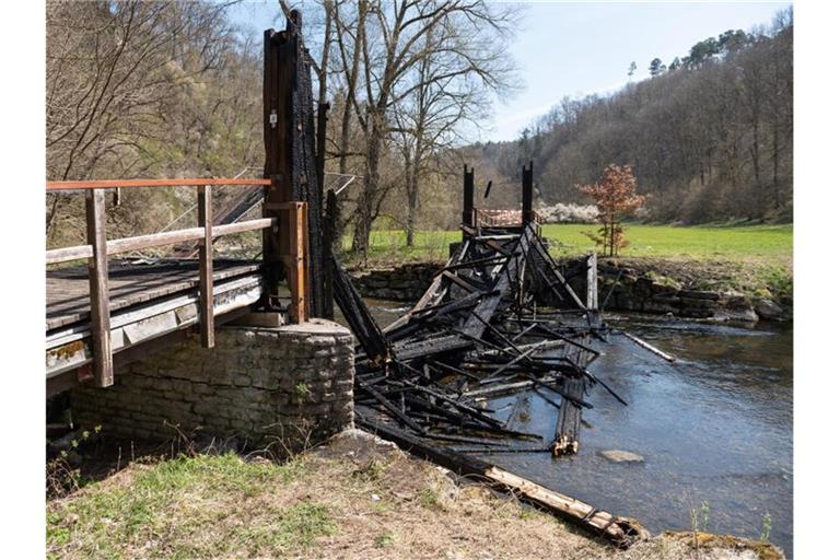 Die verkohlten Überreste der Schindelbrücke liegen im Neckar. Foto: Silas Stein/dpa/Archivbild