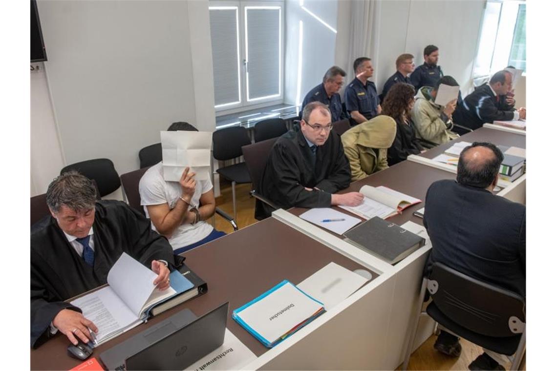 Die vier Angeklagten sitzen neben ihren Anwälten im Verhandlungssaal des Amberger Amtsgerichts. Foto: Armin Weigel