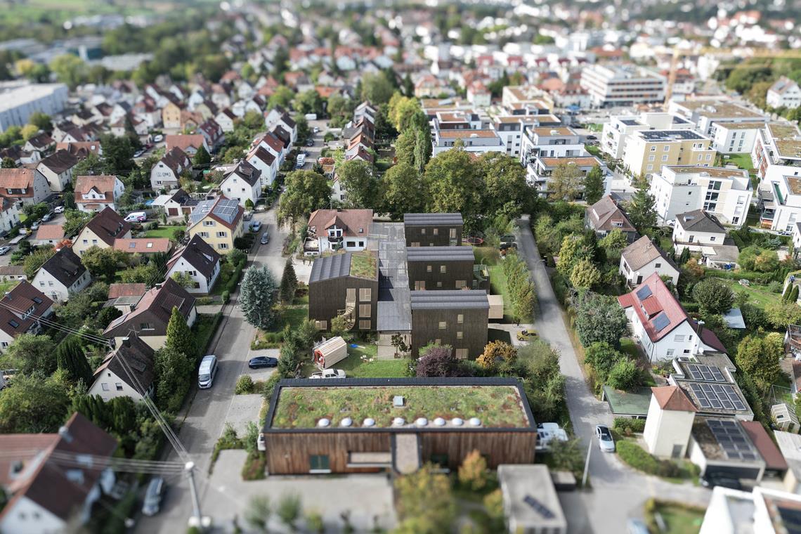 Neues Backnanger Wohnprojekt gegen die Anonymität Die Visualisierung zeigt die vier geplanten Häuser mit dunkler Fassade und das weiße Bestandsgebäude, die durch eine „Dorfstraße“ mit Glasdach miteinander verbunden sind. Im Vordergrund das 2017 eröffnete Geburtshaus. Visualisierung: Plus Bauplanung