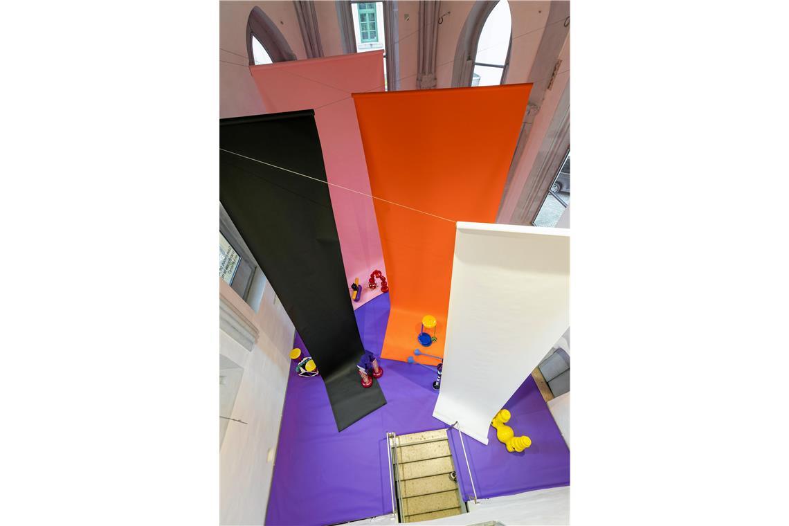 Der Chorraum der Galerie der Stadt Backnang wird zur Bühne Die von der Decke hängenden großen Papierbahnen verändern die Raumwirkung.