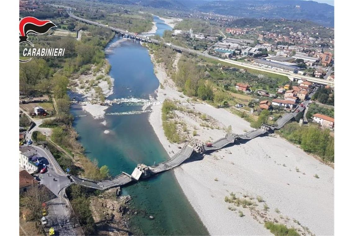 Die von der Polizei zur Verfügung gestellte Luftaufnahme zeigt die eingestürzte Brücke über einem Fluss. Foto: Carabinieri/dpa