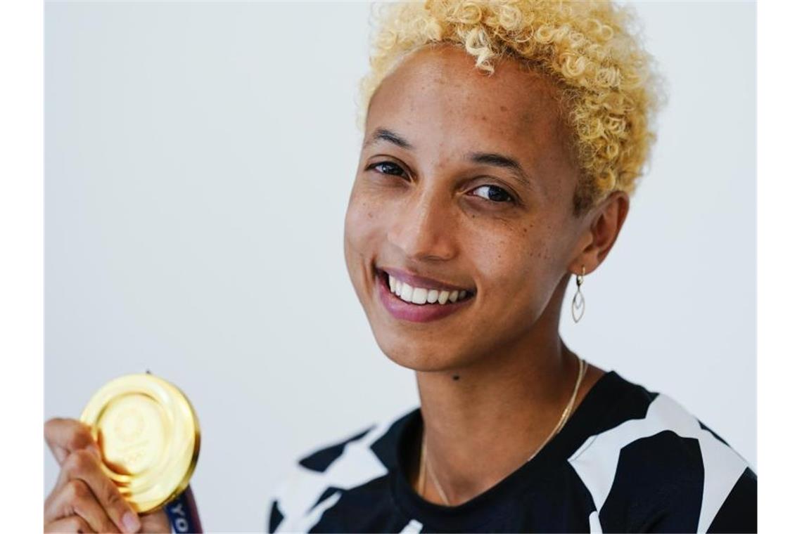 Die Weitspringerin und Olympiasiegerin Malaika Mihambo hält die olympische Goldmedaille in der Hand. Foto: Uwe Anspach/dpa