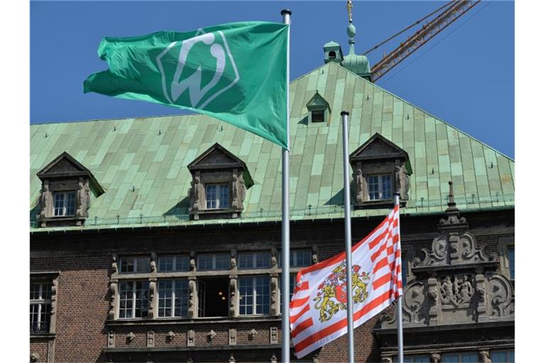 Die Werder-Fahne und Bremer Speckflagge wehen in Bremen vor dem Rathaus. Foto: Carmen Jaspersen/dpa/Archivbild