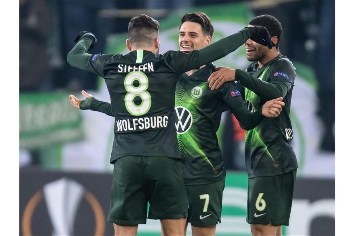 Die Wolfsburger Renato Steffen (l-r), Josip Brekalo und Wolfsburgs Paulo Otavio jubeln nach dem 1:0 nach Videobeweis. Foto: Swen Pförtner/dpa