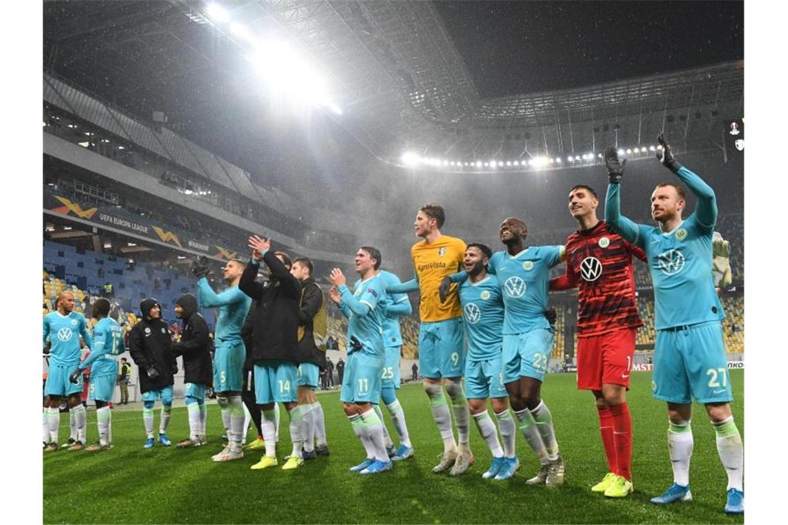 Die Wolfsburger Spieler feiern nach Abpfiff mit den Fans den Sieg. Foto: Swen Pförtner/dpa