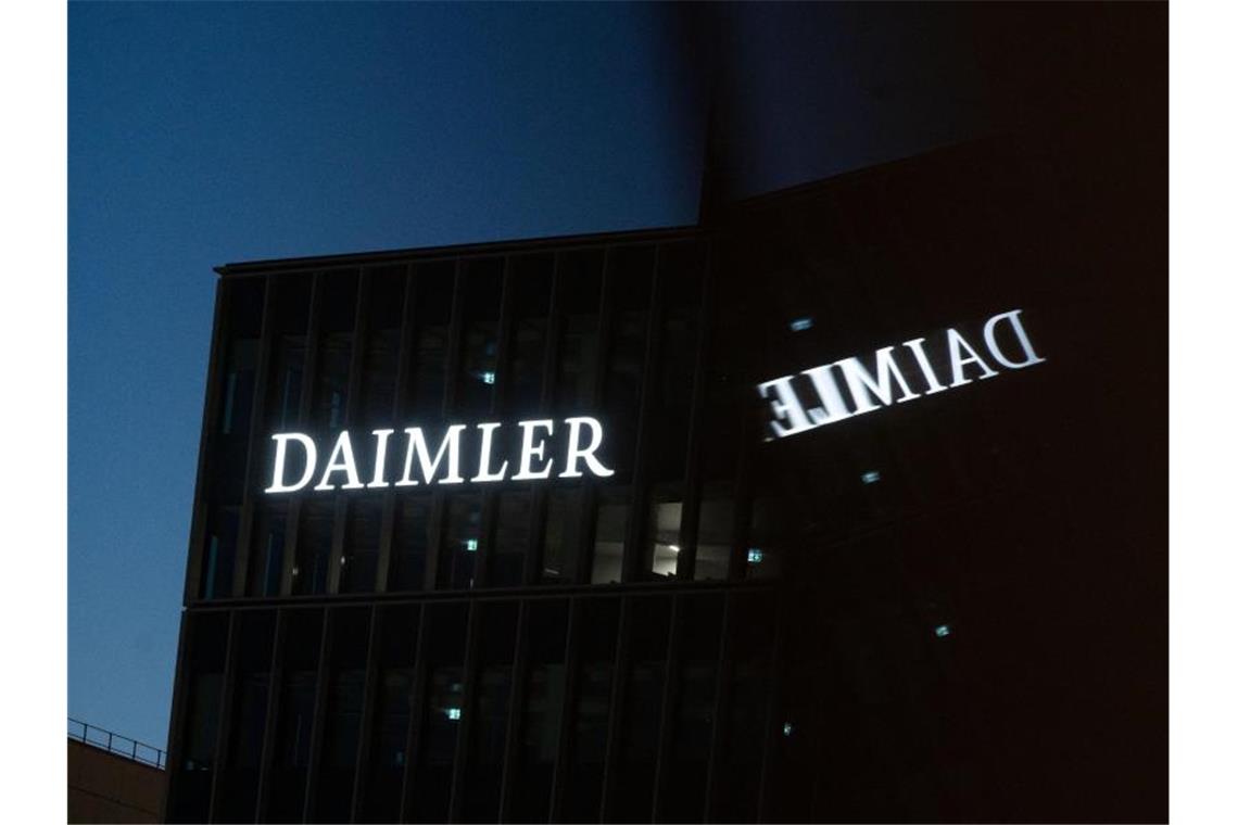 Daimler-Geschäft mit Lkw und Bussen wird unabhängig Die Zentrale der Daimler AG wird in einem Fenster reflektiert. Foto: Marijan Murat/dpa/Archiv