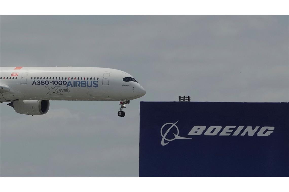 Airbus sammelt bei Messe Aufträge ein - Boeing geht leer aus Die zwei großen Konkurrenten: Ein Airbus fliegt bei einer Vorführung auf der Luftfahrtmesse Salon du Bourget an einem Logo von Boeing vorbei.