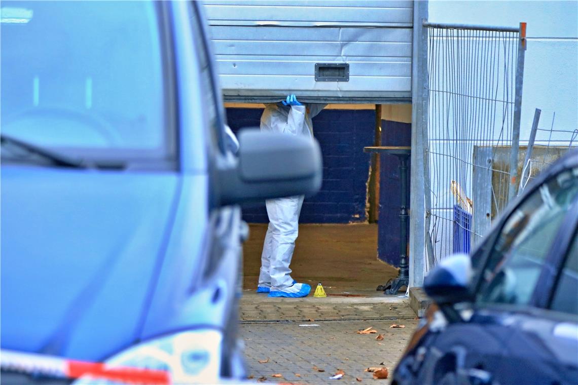 Dienstagnachmittag: Ein Beamter der Spurensicherung mit Schutzanzug und Plastiküberzügen an den Schuhen untersucht den Tatort, eine Autowerkstatt im Waiblinger Industriegebiet Eisental. Foto: G. Habermann