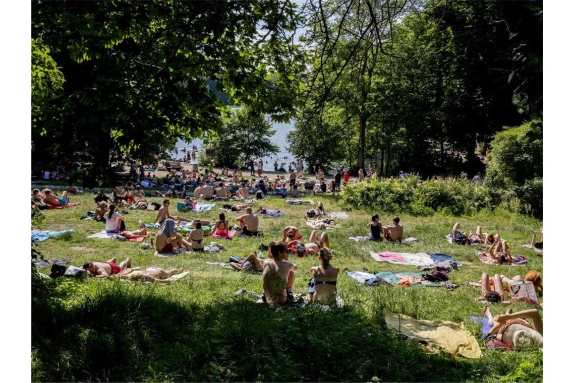 Hitze in Deutschland bringt möglicherweise Temperaturrekord Diese Ausflügler am Ufer des Schlachtensees in Berlin proben schon einmal probate Mittel gegen die kommende Hitze. Foto: Christoph Soeder