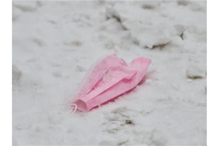 Dieser Mund-Nasen-Schutz hat ausgedient: Eine pinke Maske im Schnee. Foto: Annette Riedl/dpa/Symbolbild/Archiv
