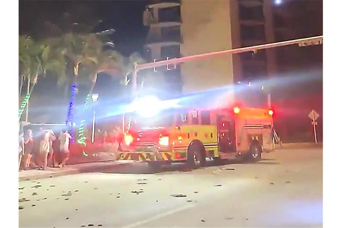 „Wie Bombeneinschlag“: Wohnhaus nahe Miami Beach stürzt ein Dieses Videostandbild zeigt Rettungskräfte der Feuerwehr nach einem Gebäudeeinsturz. Foto: Jamal Akakpo/AP/dpa