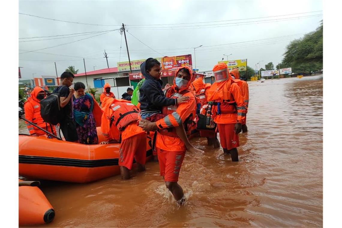 Dieses vom indischen Katastrophenschutz (NDRF) zur Verfügung gestellte Foto zeigt Rettungskräfte des Katastrophenschutzes beim Retten von Bewohnern der Gegend um Chiplun. Foto: Uncredited/NDRF/dpa