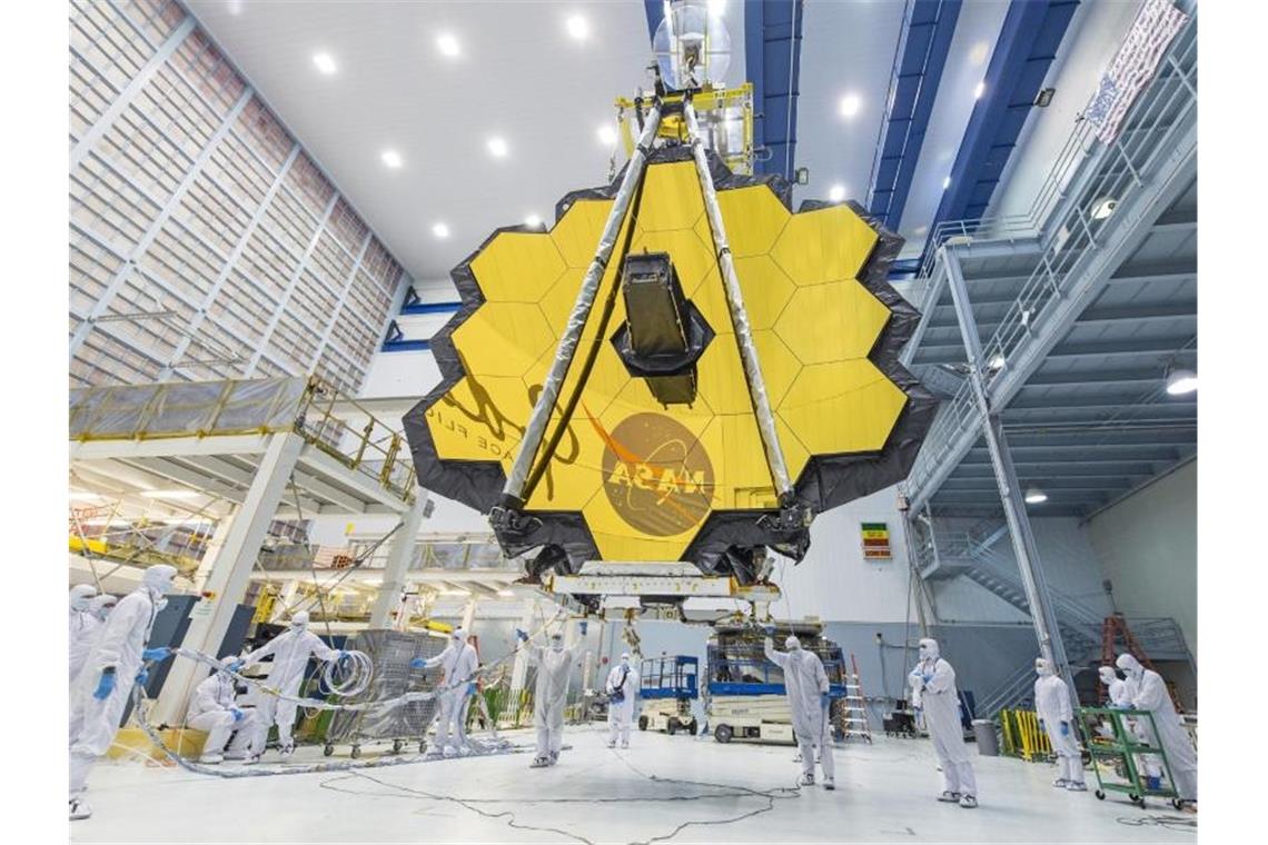 Riesiger Spiegel von Weltraumteleskop ausgefahren Dieses von der Nasa zur Verfügung gestellte Foto zeigt Techniker mit dem Spiegel des „James Webb“-Teleskops während des Baus. Foto: Uncredited/NASA/AP/dpa