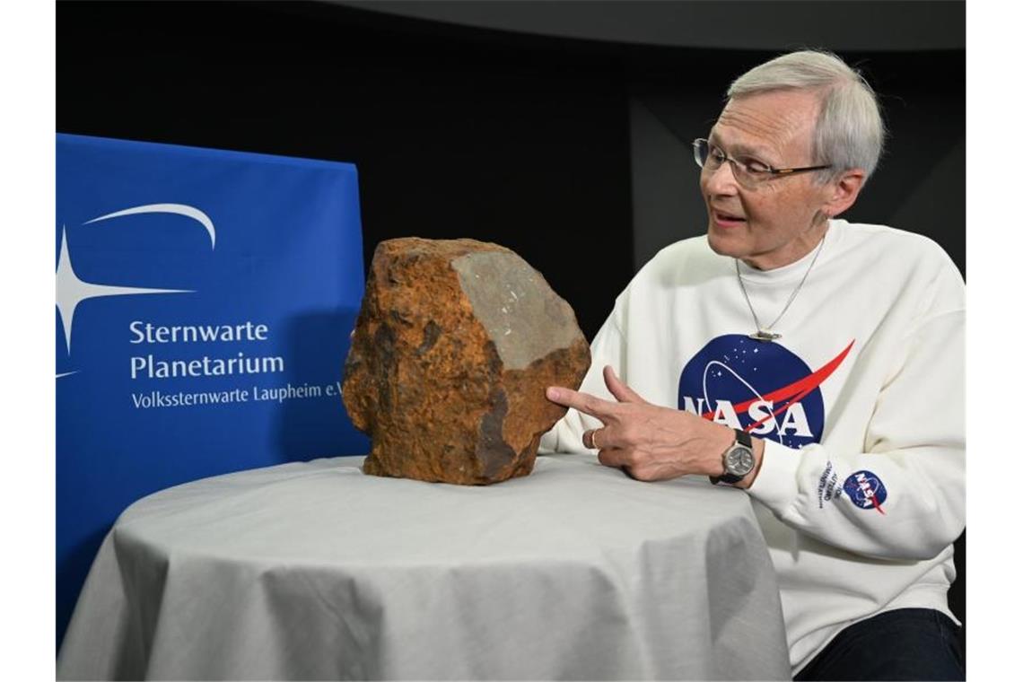 Dieter Heinlein, Meteoritenexperte des Deutschen Zentrums für Luft- und Raumfahrt (DLR), gibt neben dem Meteoriten ein Interview. Foto: Felix Kästle/dpa