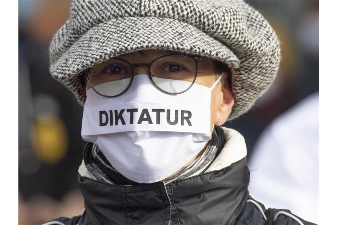 "Diktatur" steht auf der Nase-Mund-Bedeckung" einer Teilnehmerin an einer "Querdenken"-Demonstration in Frankfurt am Main. Foto: Boris Roessler/dpa