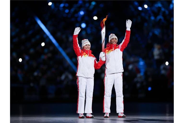 Dinigeer Yilamujiang (l) und Zhao Jiawen mit der Olympischen Fackel bei der Eröffnungsfeier. Foto: Cao Can/XinHua/dpa