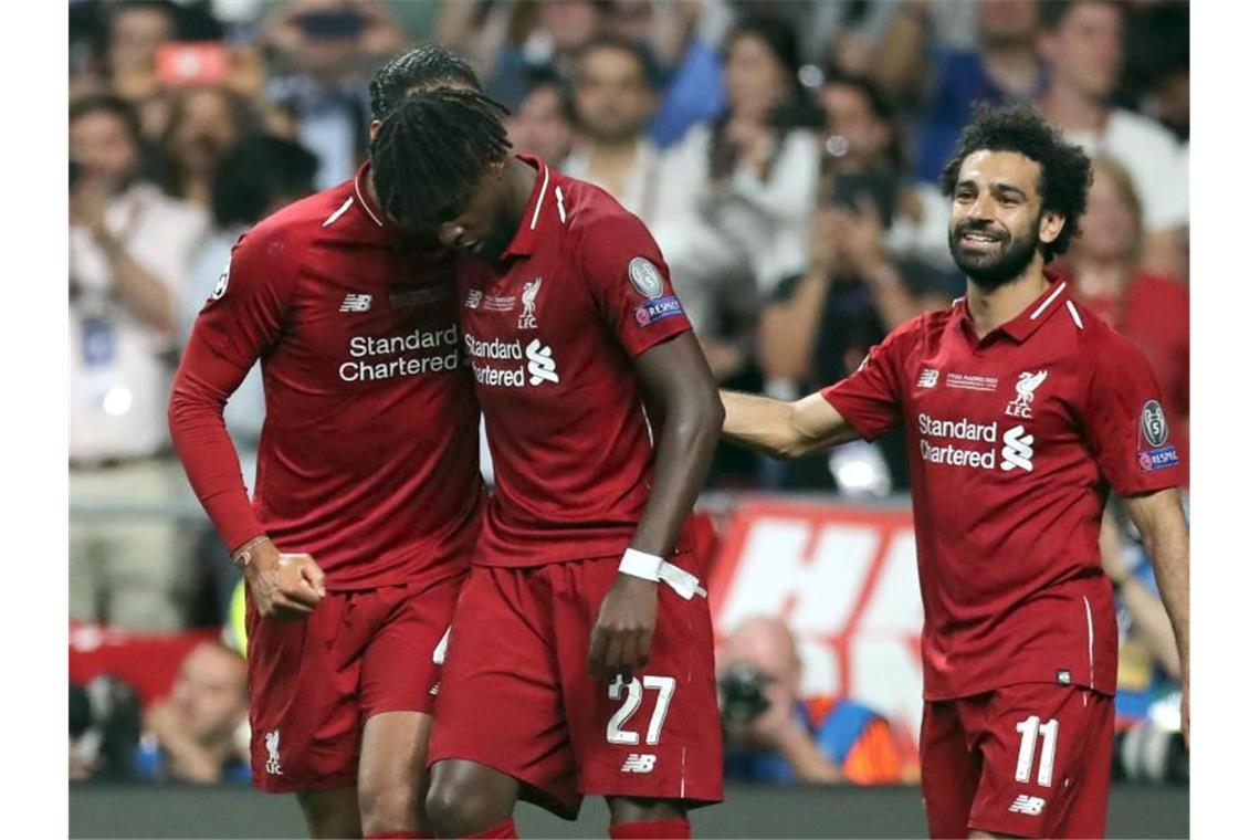 Divock Origi (M) wird für sein Tor zum 2:0 von van Dijk und Salah (r) gefeiert. Foto: Jan Woitas