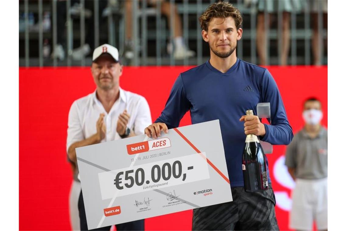 Am Ende platt: Haas das Zugpferd auf Berliner Tennis-Woche Dominic Thiem mit dem 50.000-Euro-Siegerscheck. Foto: Andreas Gora/dpa