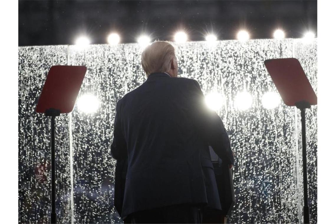 Donald Trump hält bei Regen seine Rede hinter einem Sicherheitsglas. Foto: Carolyn Kaster/AP