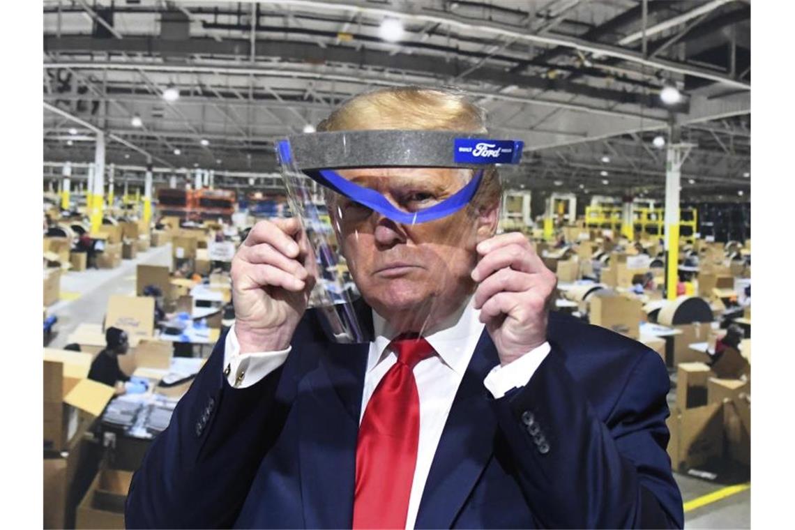Trump trägt bei Fabrik-Besuch erneut keine Schutzmaske Donald Trump hält während des Rundgangs in einem Ford-Werk ein Gesichtsvisier in den Händen - einen Mundschutz trug er trotz Aufforderung nicht. Foto: Daniel Mears/Detroit News/AP/dpa