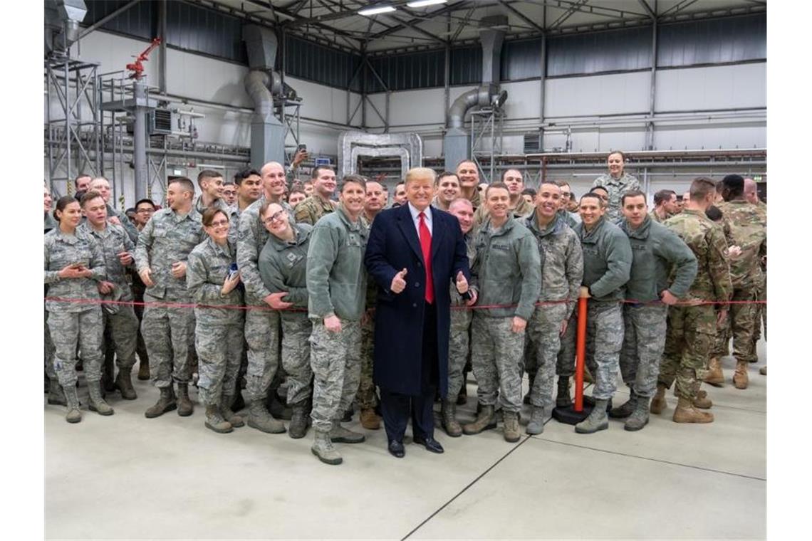 Fast 10.000 US-Soldaten sollen Deutschland verlassen Donald Trump lässt sich 2018 während eines Zwischenstopps auf dem Stützpunkt der US-Luftwaffe in Ramstein mit Militärangehörigen fotografieren. Foto: Shealah Craighead/White House /dpa