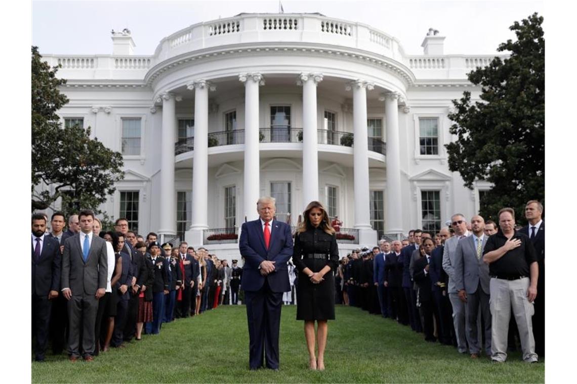 Donald Trump legt gemeinsam mit Ehefrau Melania Trump und Gästen eine Schweigeminute vor dem Weißen Haus zum 18. Jahrestag der Terroranschläge ein. Foto: Evan Vucci/AP