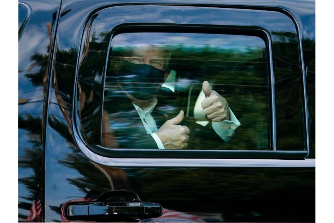 Donald Trump ließ sich am Samstag im Auto an seinen vor dem Krankenhaus wartenden Anhängern vorbeifahren. Der US-Präsident will ins Weiße Haus zurückkehren. Foto: Tia Dufour/White House/dpa
