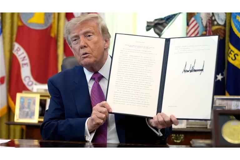 Donald Trump, Präsident der USA, hält im Oval Office des Weißen Hauses eine unterzeichnete Executive Order in die Höhe.