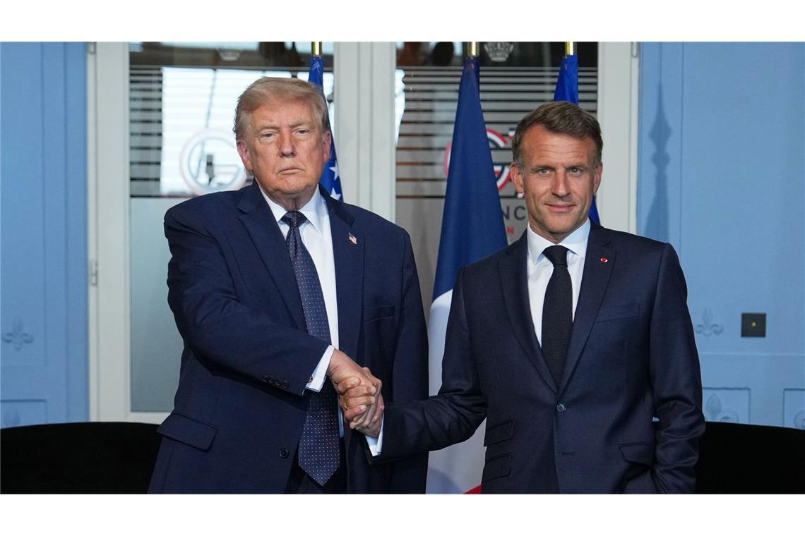 Donald Trump , Präsident der USA, und Emmanuel Macron, Präsident von Frankreich, reichen sich die Hände vor einem  Gespräch am Rande eines G7 Gipfels.
